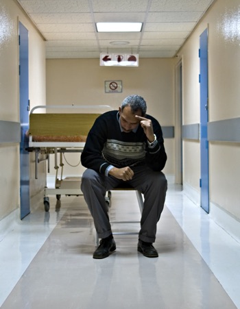 Man waiting in a hospital hallway.